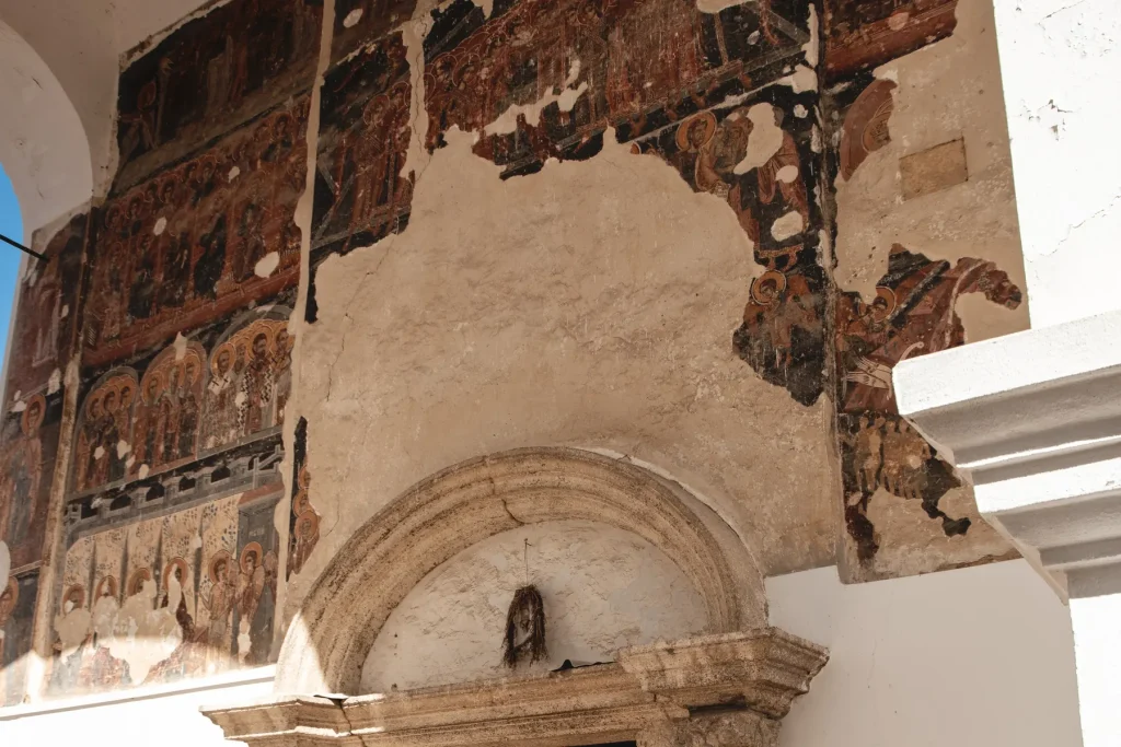 Stare freske sa svetiteljima iznad kamenog portala na ulazu u crkvu manastira Krušedol