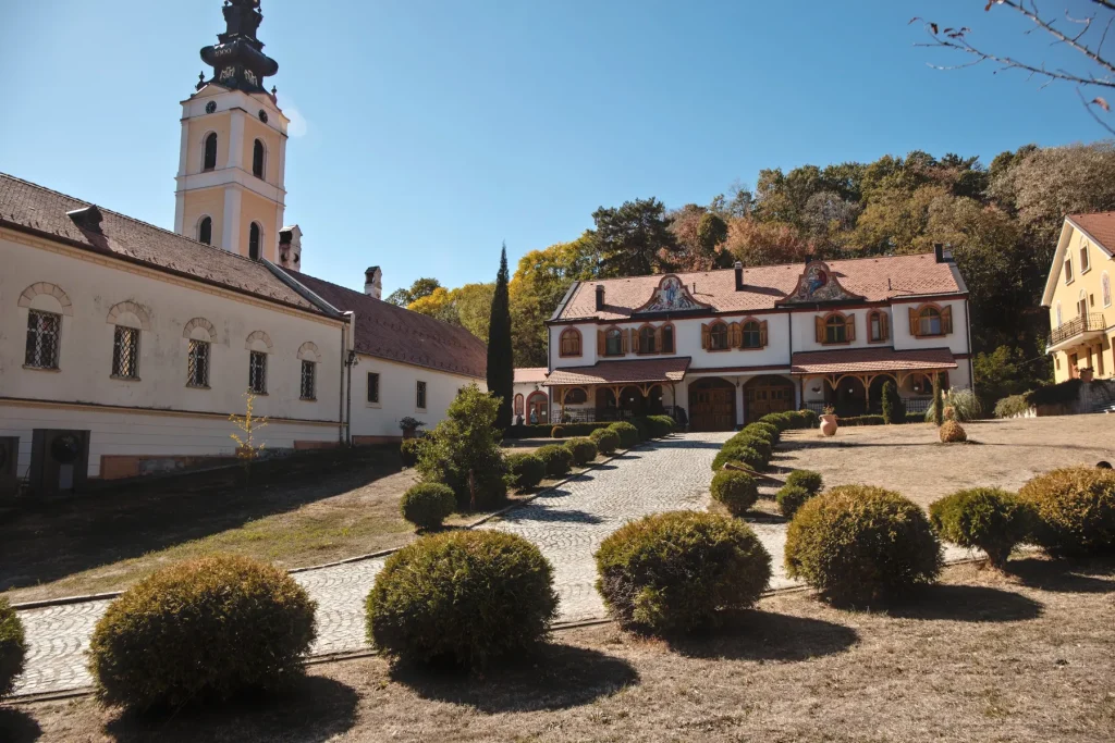 Visoki barokni zvonik crkve manastira Grgeteg, konaci i uređeno dvorište sa okruglim žbunjem